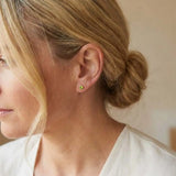 Peridot birthstone stud earrings on model, bright green studs at ear