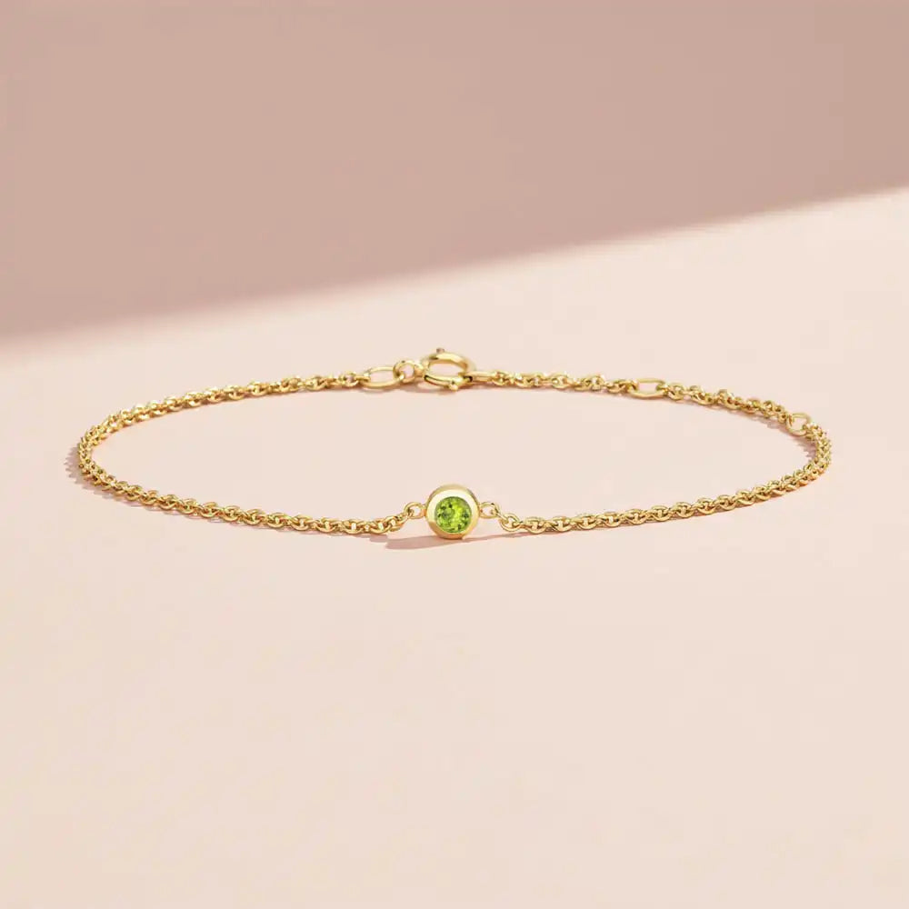 Bezel-set peridot bracelet in 14K yellow gold on adjustable curb chain