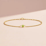 Bezel-set peridot bracelet in 14K yellow gold on adjustable curb chain