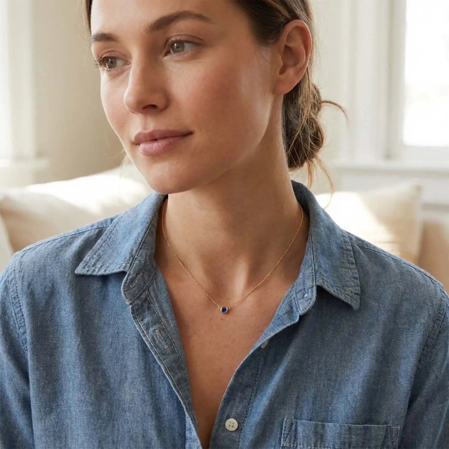 Bezel-set sapphire necklace on model, layered at the collarbone
