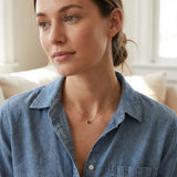 Bezel-set sapphire necklace on model, layered at the collarbone