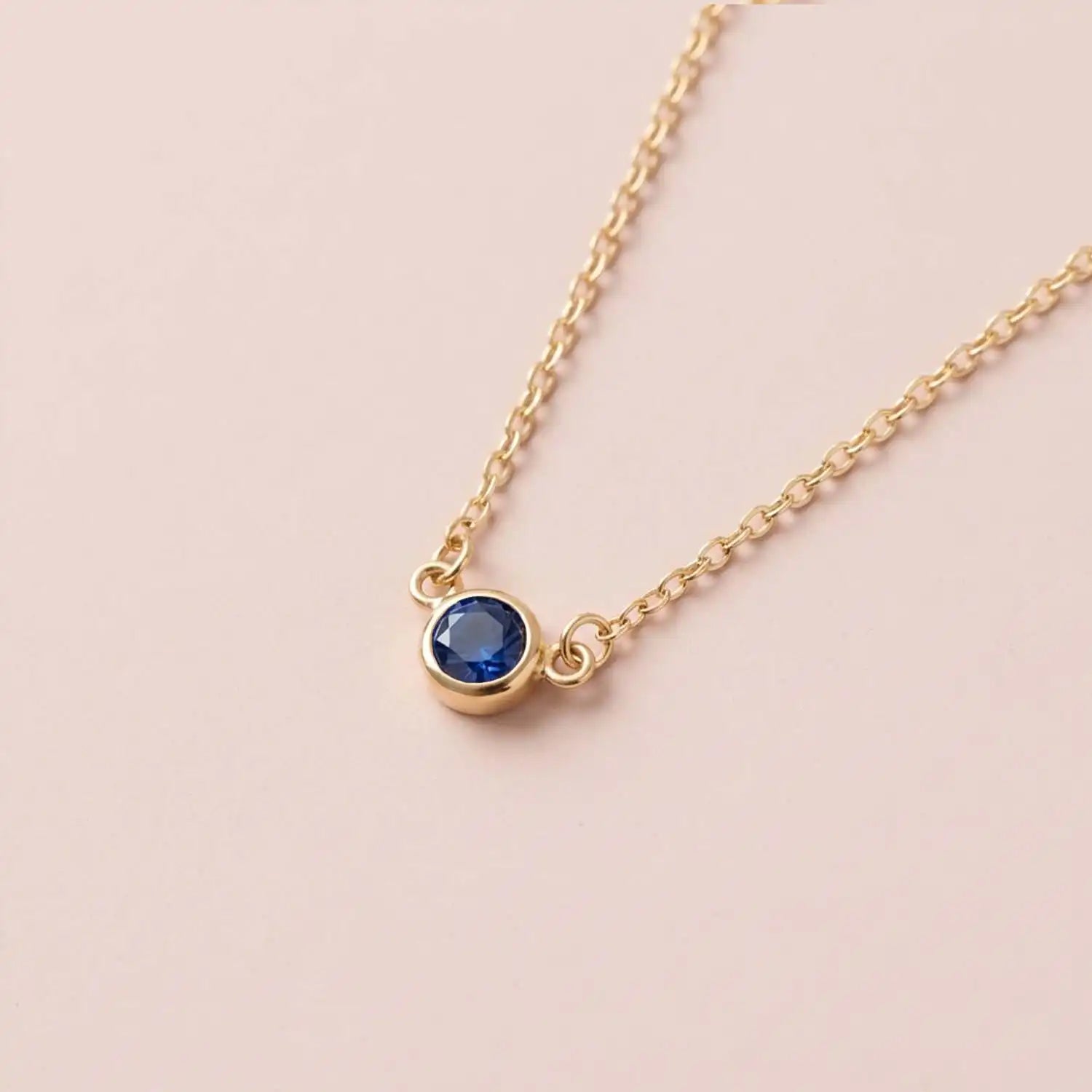 Bezel-set sapphire birthstone necklace in 14K yellow gold on cable chain variant--Sterling silver