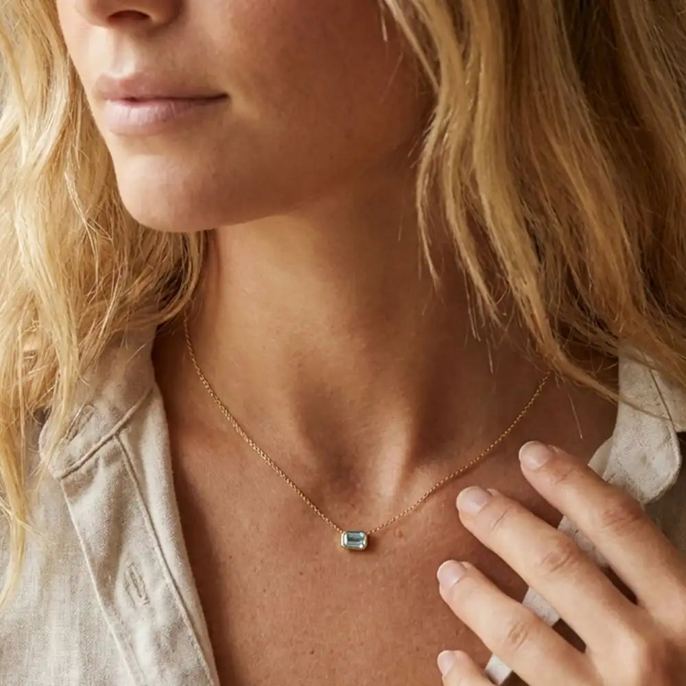 Minimalist birthstone necklace featuring Swiss Topaz shown on model variant--14K-yellow-gold variant--14K-white-gold variant--14K-rose-gold variant--Sterling-silver variant--Swiss-topaz