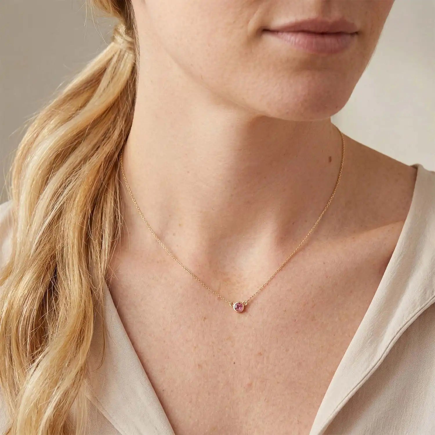 Bezel-set tourmaline necklace on model, layered at the collarbone