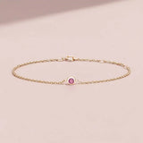 Bezel-set tourmaline bracelet flatlay showing deep pink stone on curb chain yellow gold variant--14K-yellow-gold variant--Tourmaline