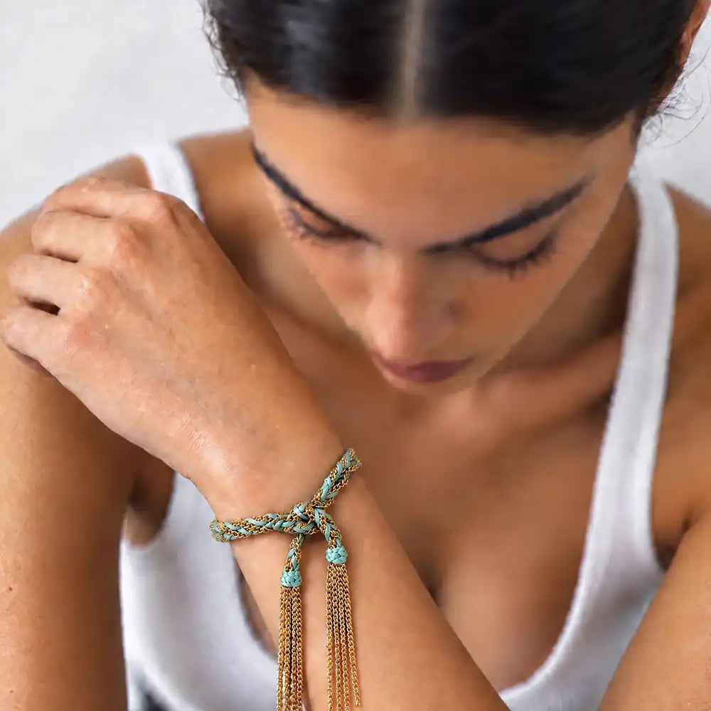 Turquoise braided chain and silk tassel bracelet in 14K gold-fill worn on model