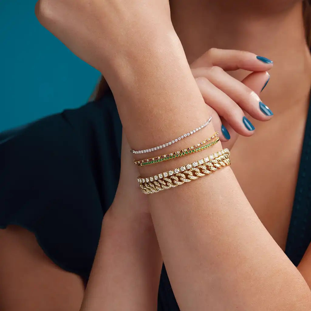 Bracelet stacked with other tennis bracelets and bangles — luxe layering

