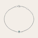 Bezel-set alexandrite bracelet flatlay showing vivid color change stone on curb chain silver variant--Sterling-silver variant--Alexandrite