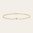 Bezel-set aquamarine bracelet flatlay showing pale blue stone on curb chain