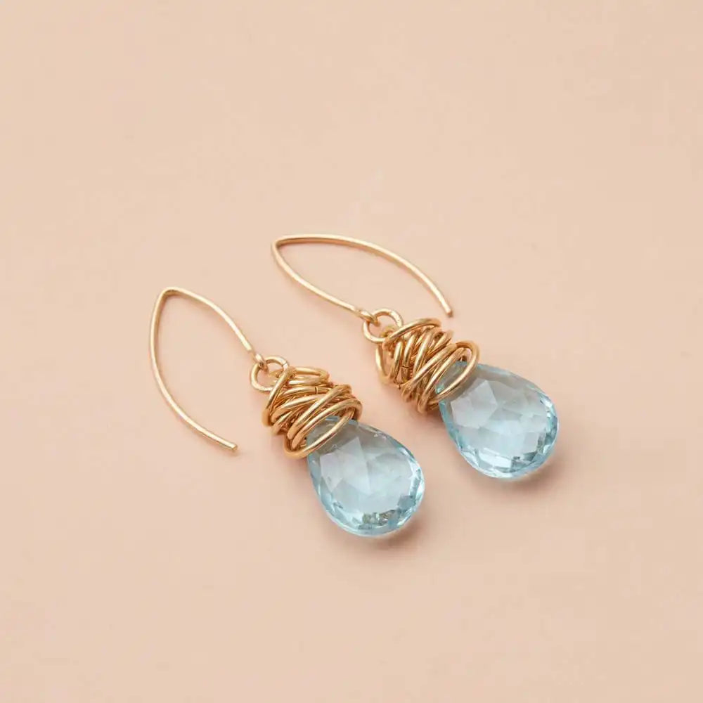 Aquamarine dangle earrings product shot, genuine ocean-blue stone in sculptural bezel setting