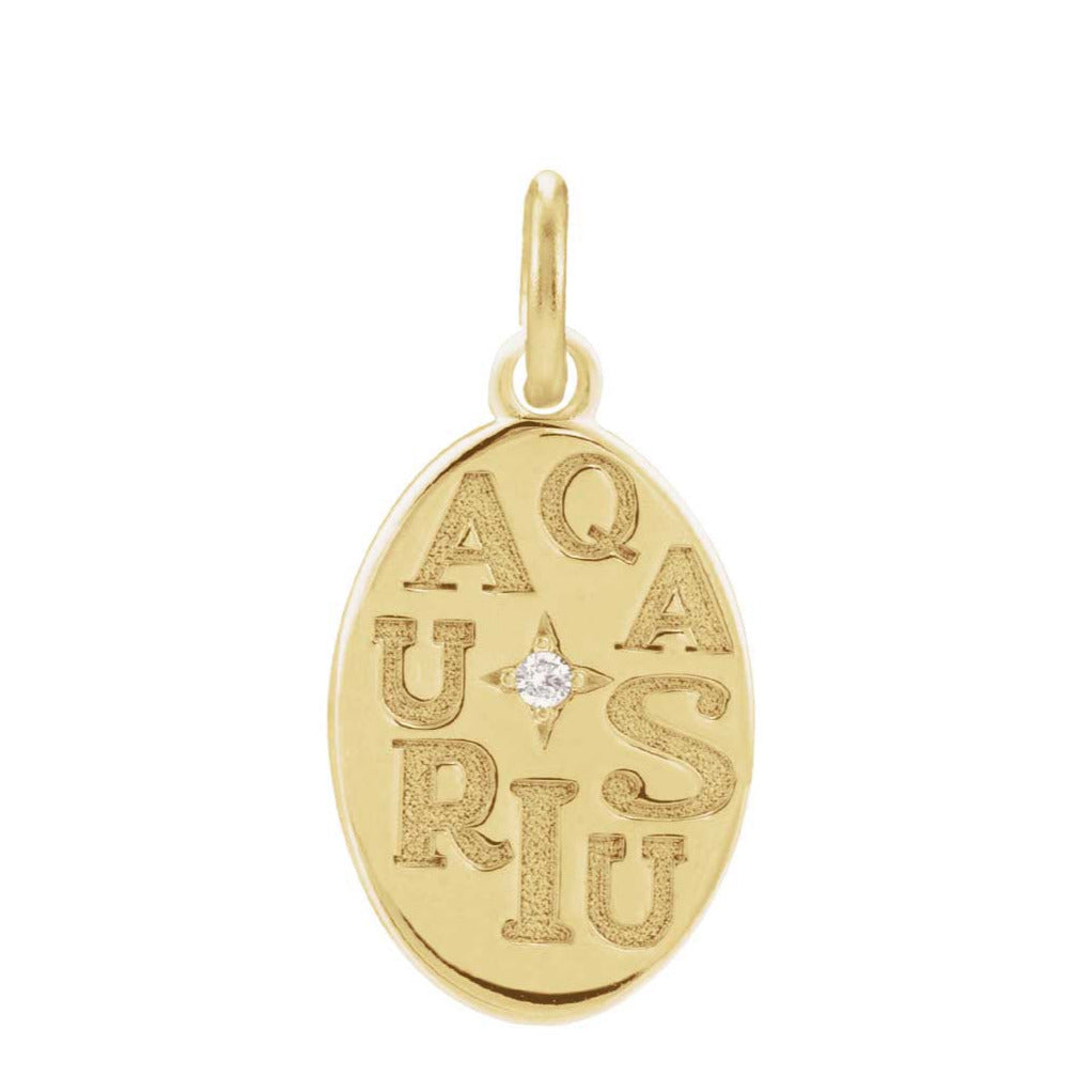 Close-up of hand-engraved Aquarius zodiac sign on charm