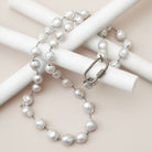 Flat lay of baroque pearl rope necklace with diamond clasp