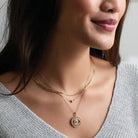 Bezel-set birthstone necklace layer on a model.