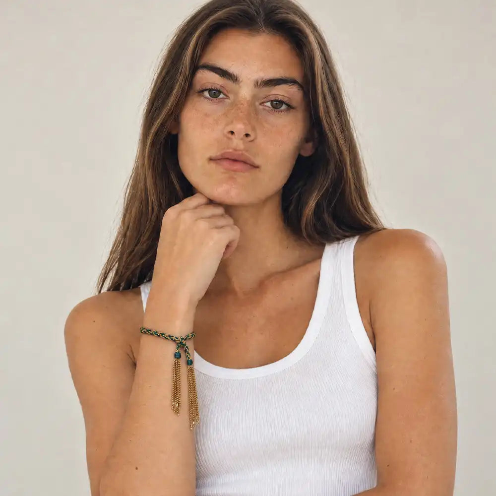 Braided chain and silk tassel bracelet worn on model with a tank top