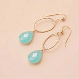 Faceted chalcedony drop earrings in yellow gold fill, soft powder-blue gemstone teardrop briolette suspended from slim oval gold link, blush background. all-groups