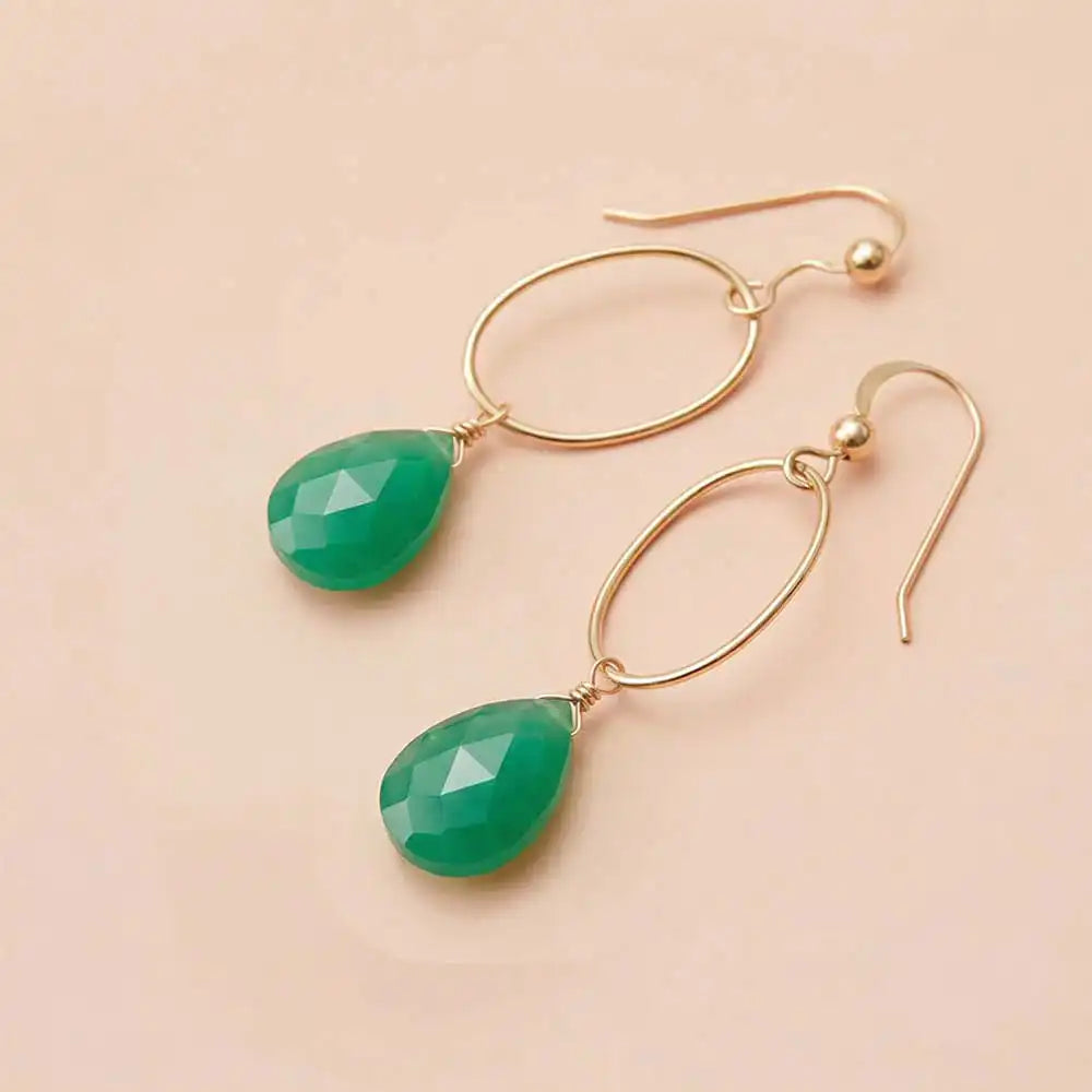 Faceted chrysoprase drop earrings in yellow gold fill, vivid apple-green gemstone teardrop briolette suspended from slim oval gold link, blush background. all-groups