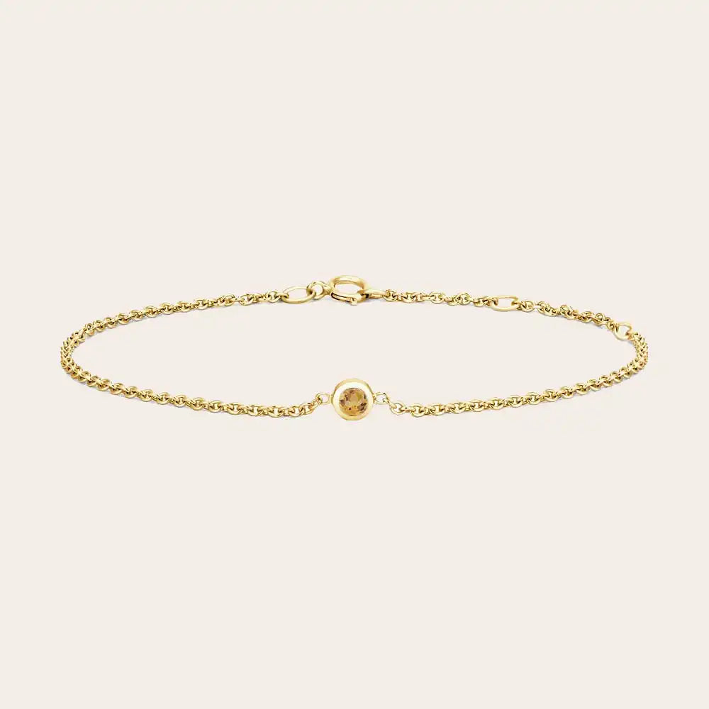 Bezel-set citrine bracelet flatlay showing warm golden stone on curb chain