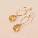 Faceted citrine drop earrings in yellow gold fill, golden yellow gemstone teardrop briolette suspended from slim oval gold link, blush background. all-groups