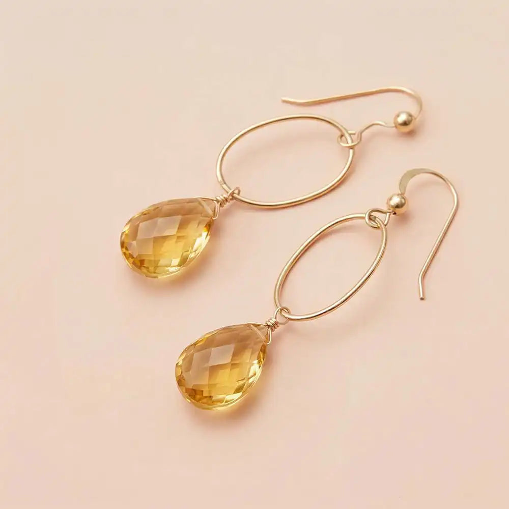 Faceted citrine drop earrings in yellow gold fill, golden yellow gemstone
teardrop briolette suspended from slim oval gold link, blush background. all-groups