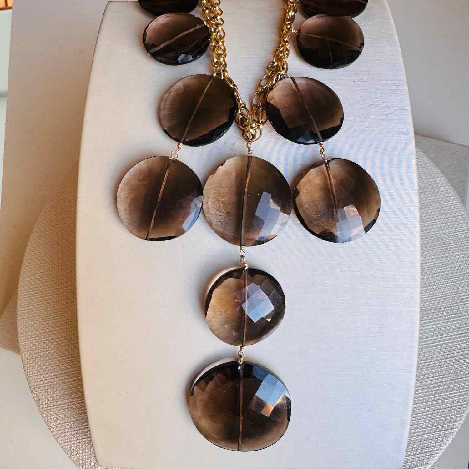 Smokey topaz bib necklace close-up showing faceted gemstone disc detail