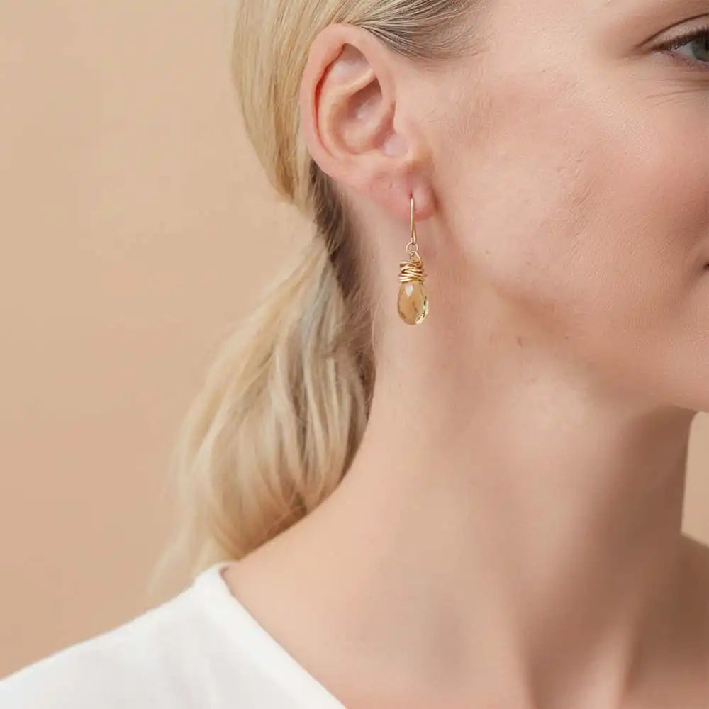Close-up of natural citrine bezel dangle earring, showing warm amber stone and handcrafted detail