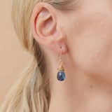 Close-up of natural london blue topaz bezel dangle earring, showing saturated inky blue stone and handcrafted detail. variant--Gold-fill variant--Sterling-silver variant--London-Topaz