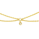 Close-up of petite natural diamonds on drape necklace, high-polish 14K yellow gold catching the light