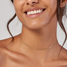 Diamond drape necklace styled on model, layered with delicate chains for everyday minimalist luxury