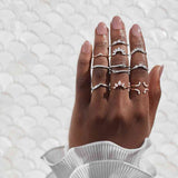 arabesque curved diamond band in 14k gold stacked with other bands on models hand