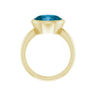 Sustainable topaz ring crafted in yellow gold, oval gemstone set across the band