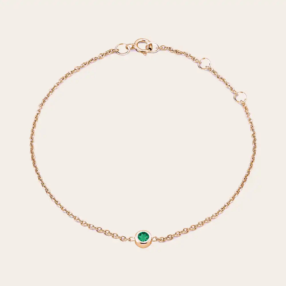 Bezel-set emerald bracelet in 14K rose gold, close-up of green stone in bezel