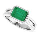 Emerald gemstone cocktail ring in 14K white gold, sleek emerald-cut design.