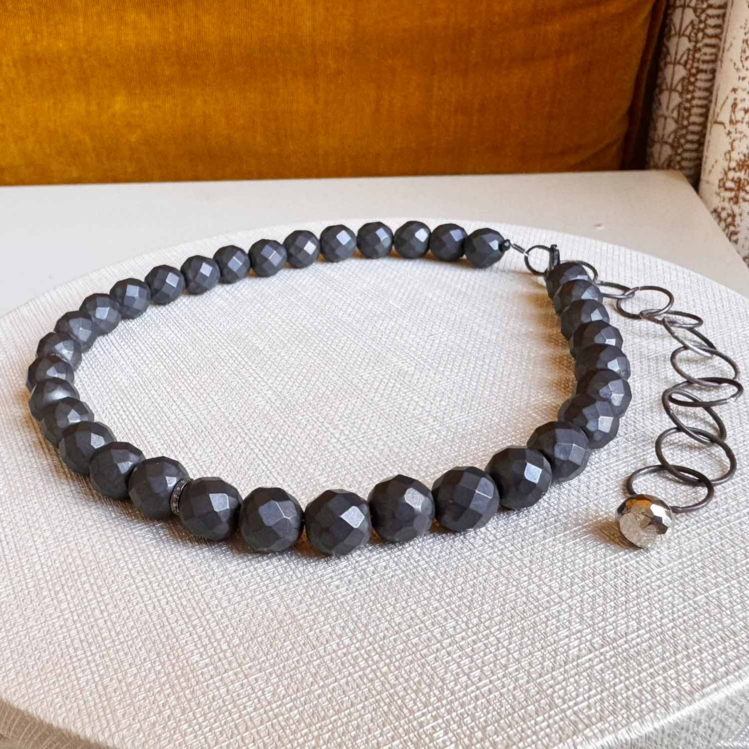 Hematite bead strand necklace, detail of reflective natural hematite surface variant--Hematite