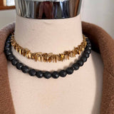 Hematite beaded necklace on model, grounding dark tones with gold accent variant--Hematite