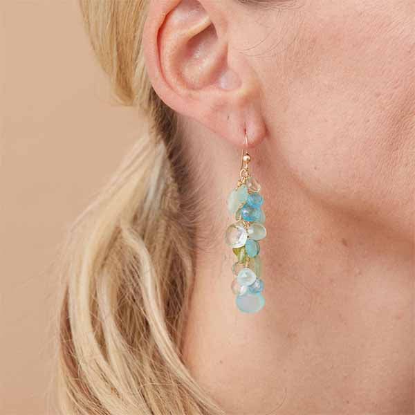 Gemstone cascade earrings worn on ear for scale