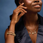 Gold diamond link bracelet stacked on model