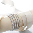 Stacked lab-grown diamond tennis bracelets in white, yellow, and rose gold