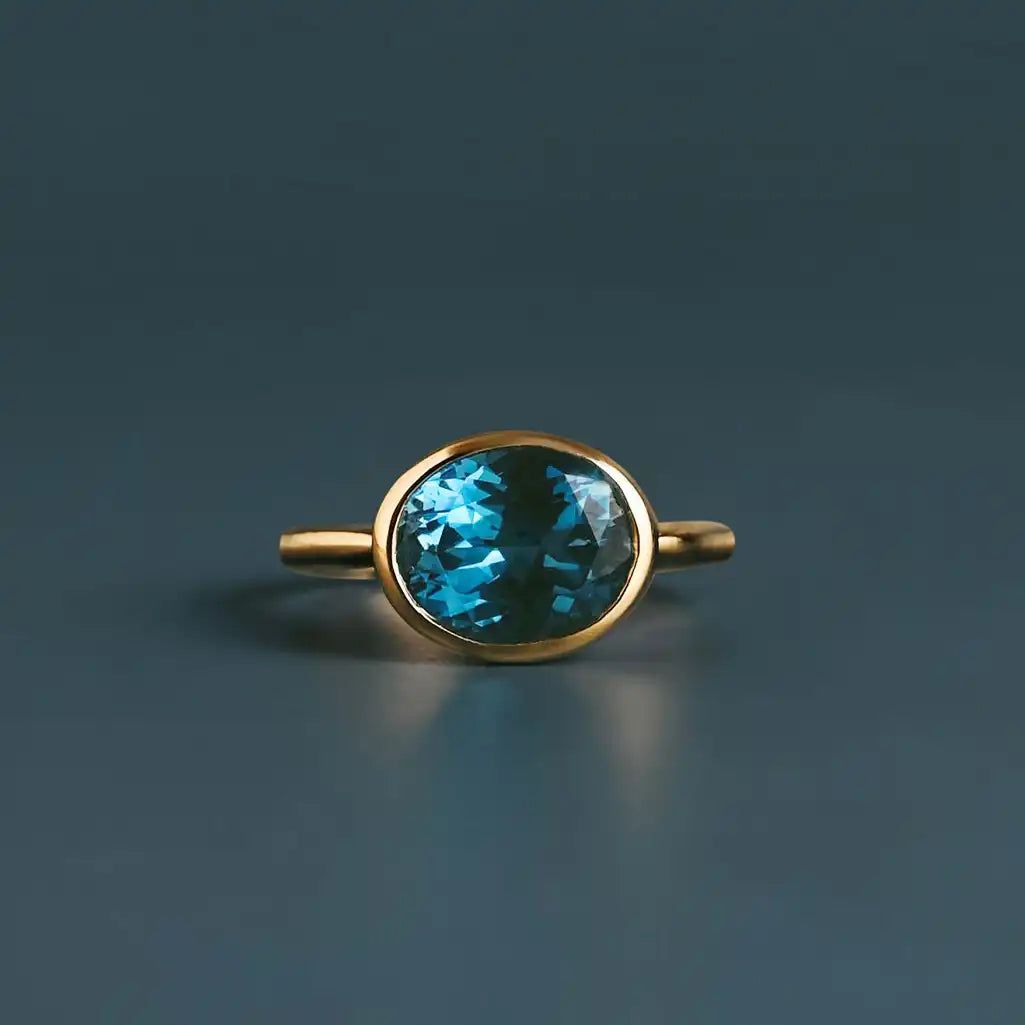 East-west London blue topaz cocktail ring in 10K yellow gold, oval stone set horizontally
