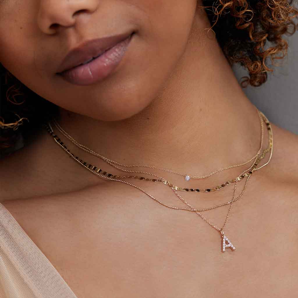 Mirror chain on model neck, close-up of flat disc links