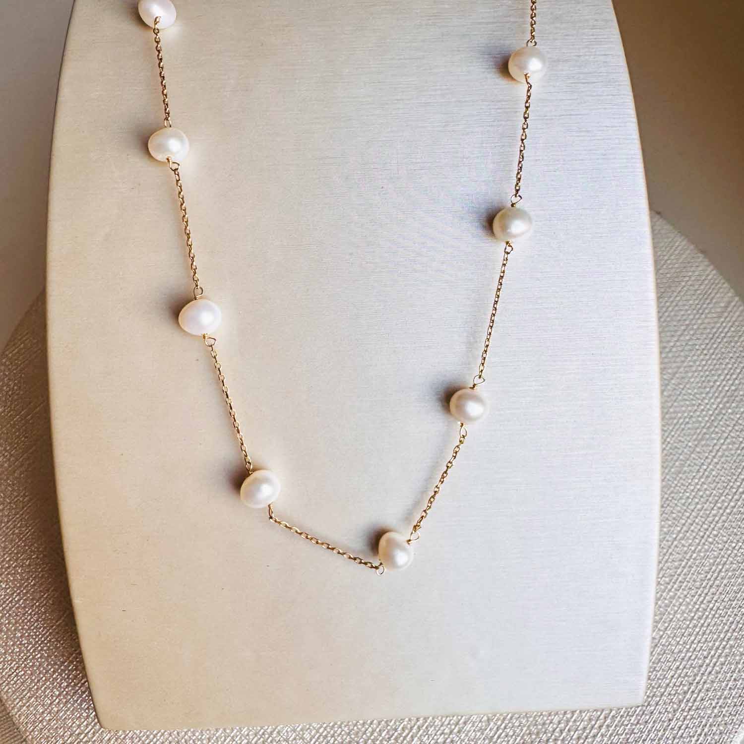 Pearl station necklace in 14K gold, close-up of pearl spacing on chain