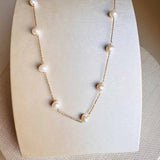 Pearl station necklace in 14K gold, close-up of pearl spacing on chain
