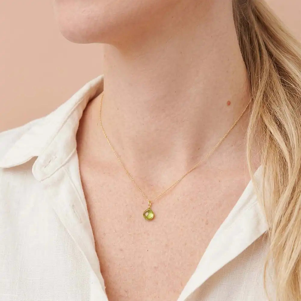 Elegant peridot gemstone necklace with light, airy silhouette on model