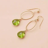 Faceted peridot drop earrings in yellow gold fill, bright lime-green gemstone teardrop briolette suspended from slim oval gold link, blush background. all-groups