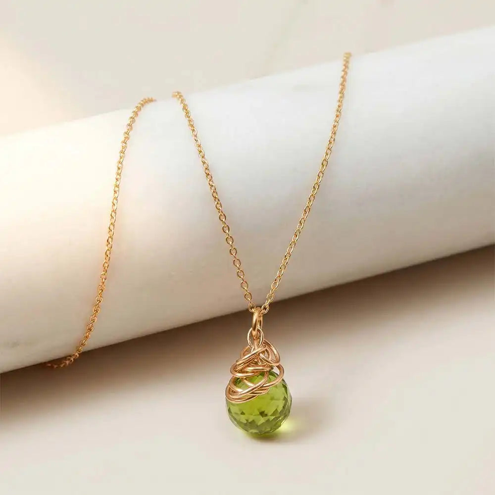 Natural peridot pendant necklace in sterling silver, styled on chain necklace
