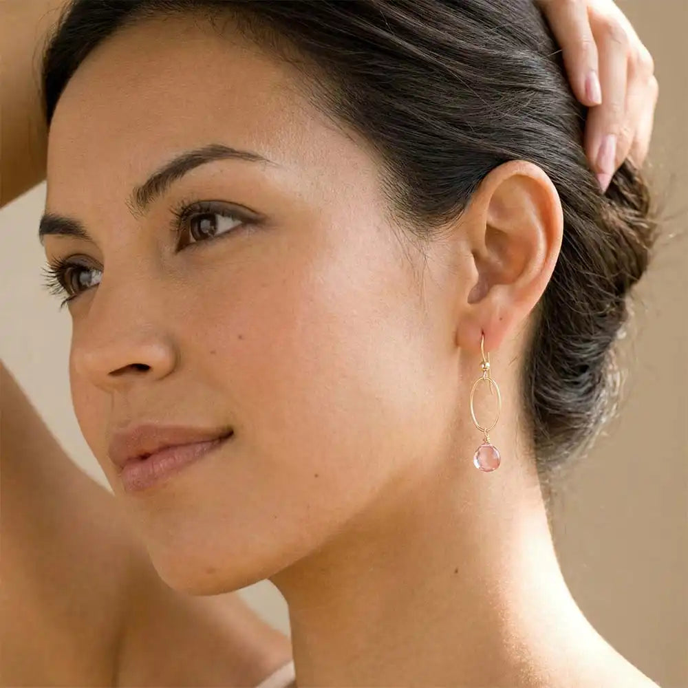 Woman wearing small faceted pink topaz hoop earrings in yellow gold fill, soft blush-pink gemstone with rosy sparkle, lifestyle portrait. all-groups