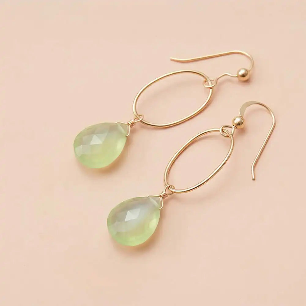 Faceted prehnite drop earrings in yellow gold fill, soft sage-green gemstone teardrop briolette suspended from slim oval gold link, blush background. all-groups