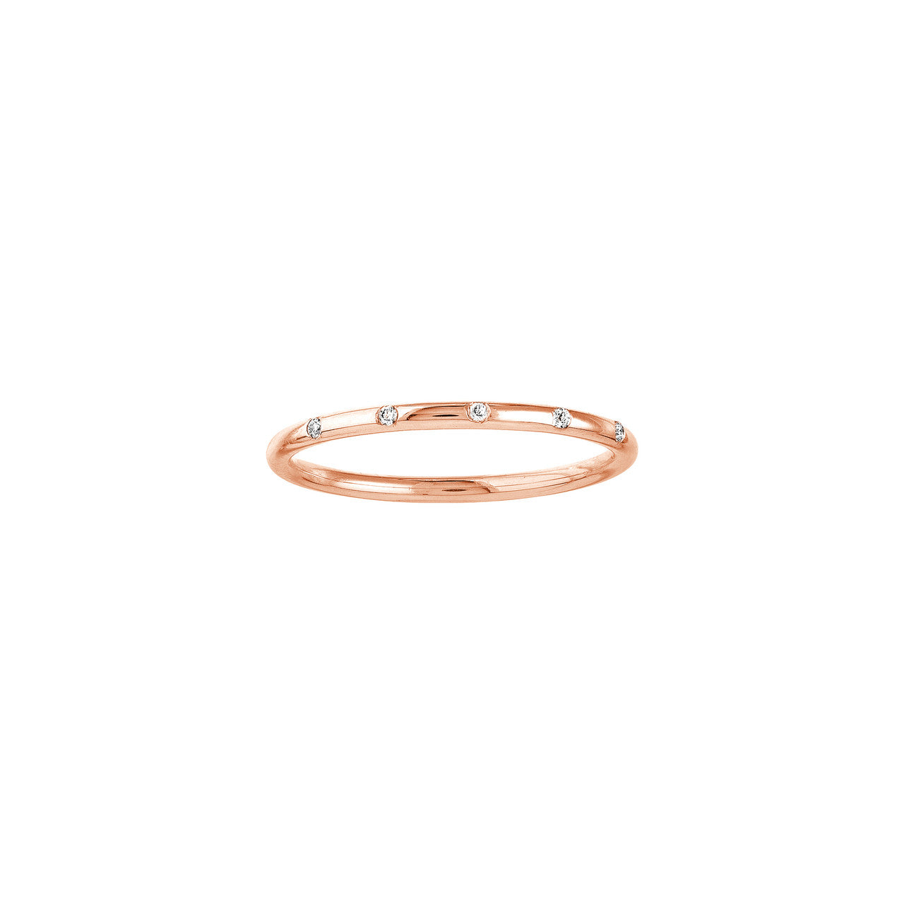 Close-up of five petite natural diamonds set along a slim 14K rose gold station band, high-polish finish