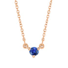 Minimalist 14K gold necklace with a small round sapphire gemstone pendant.
