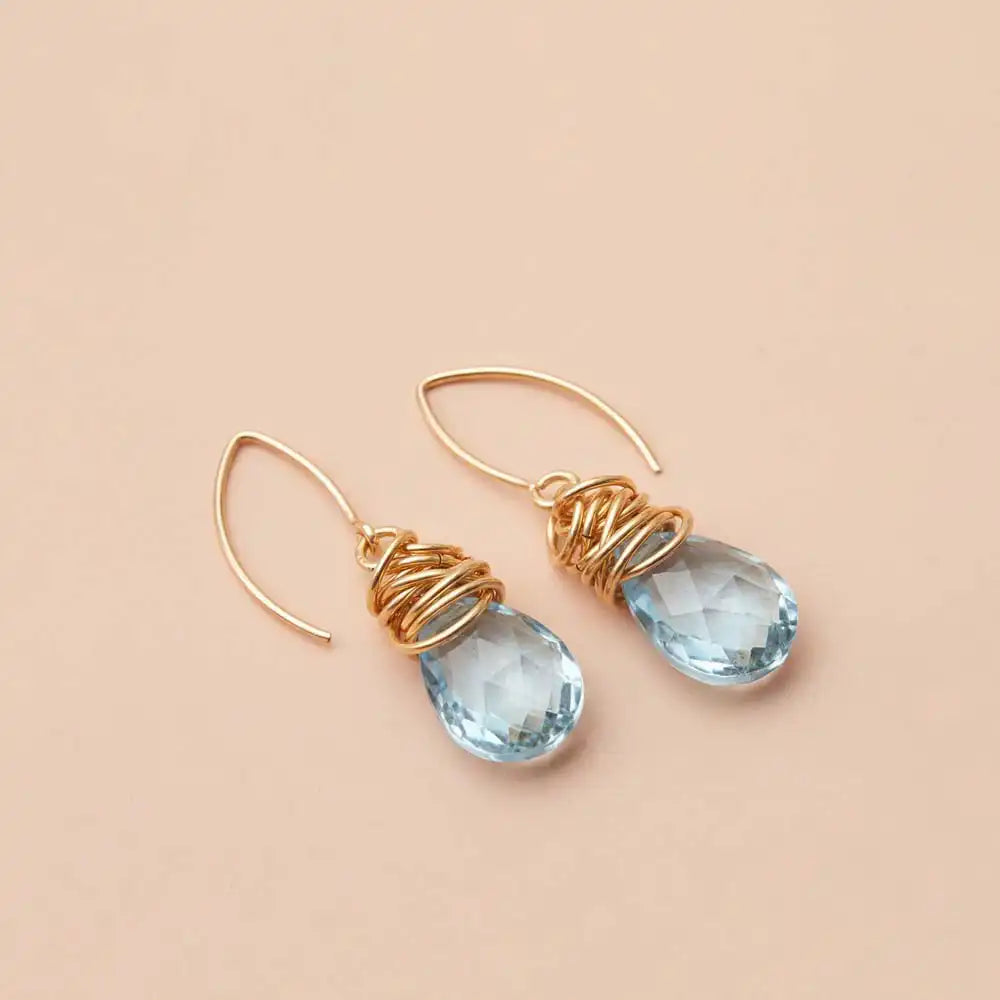 Swiss blue topaz dangle earrings product shot, genuine vivid sky-blue stone in sculptural bezel setting