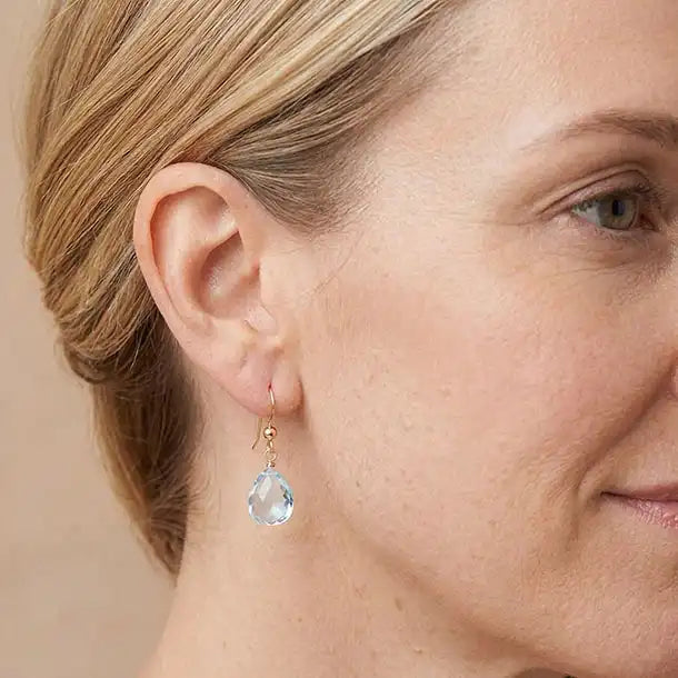 Custom gemstone drop earring in gold-fill, styled on model showing 1.5-inch drop length. variant--Gold-fill, variant--Sterling-silver, variant--14K-yellow-gold, variant--14K-white-gold variant--Swiss-Topaz